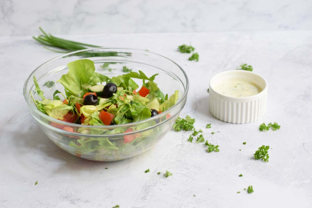A salad with a low FODMAP yoghurt dressing next to it