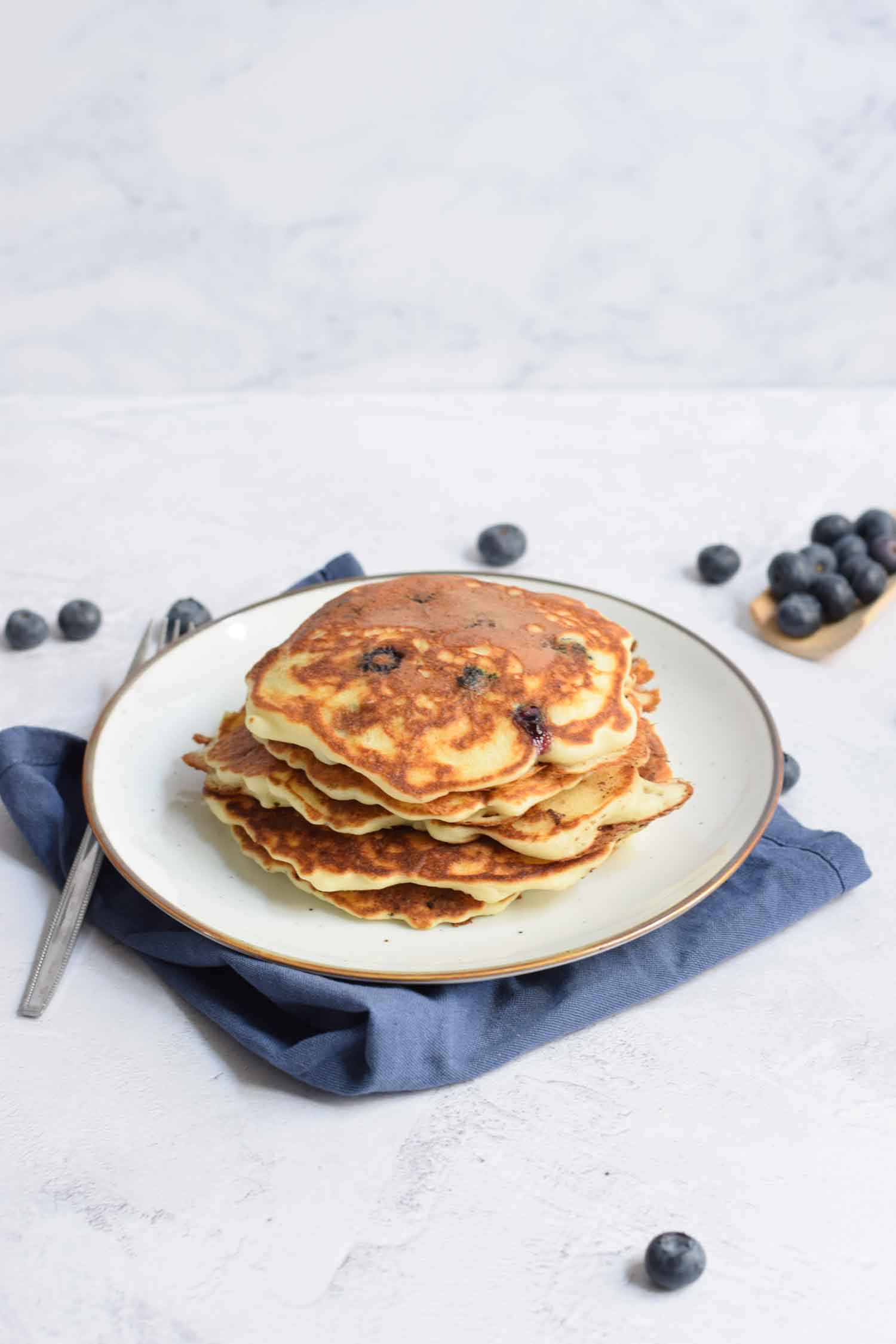 A stack of gluten-free American pancakes with blueberries on a plate
