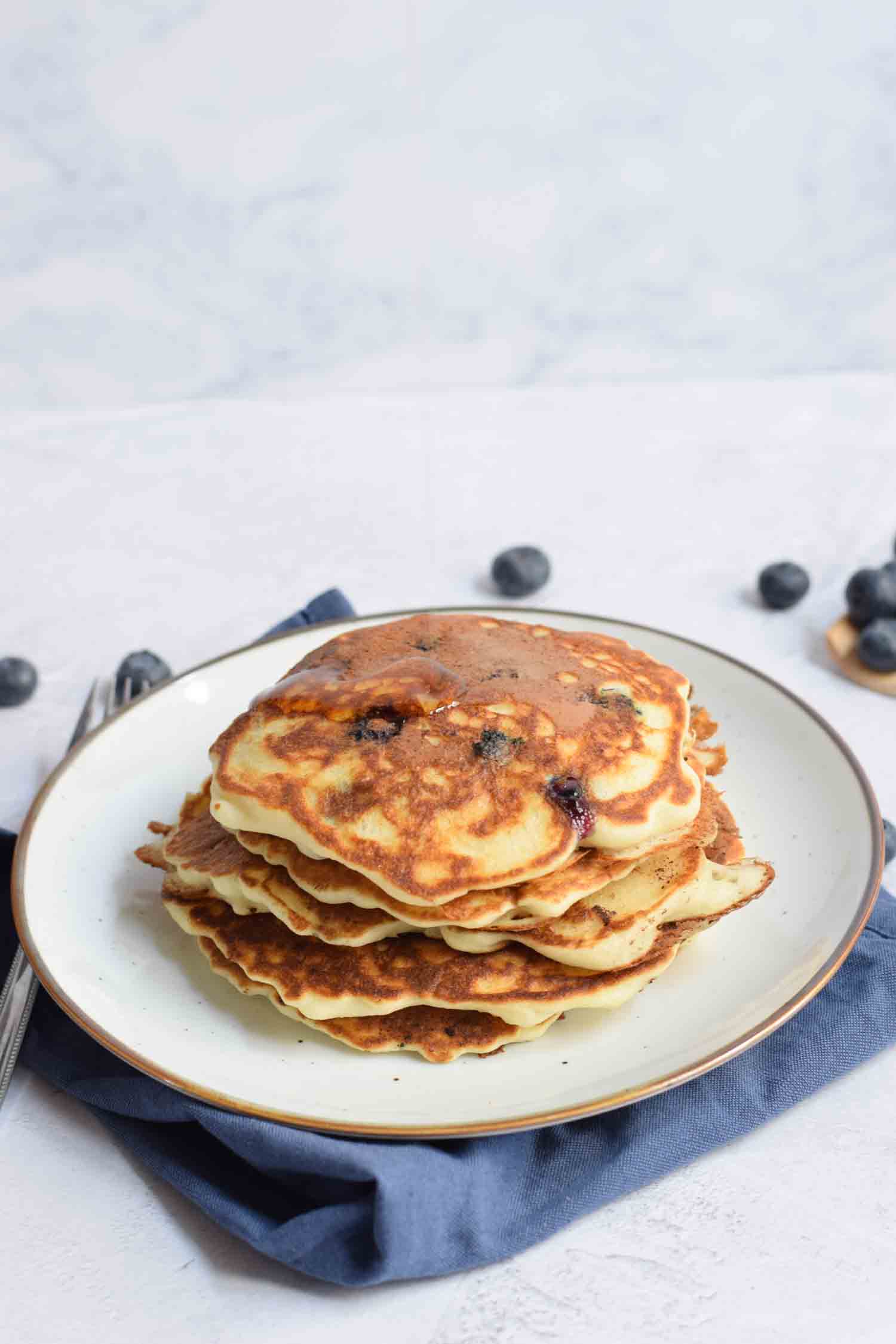 A stack of gluten-free American pancakes with blueberries on a plate
