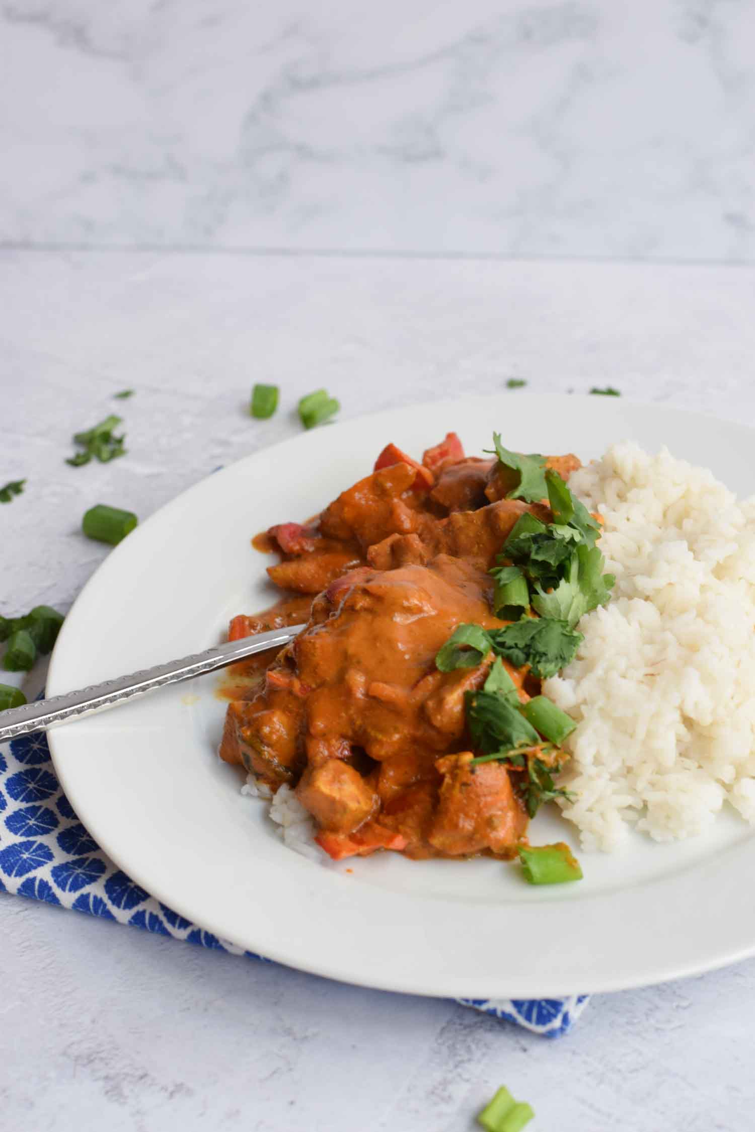 Low FODMAP chicken tikka masala with rice on a plate with a fork in it
