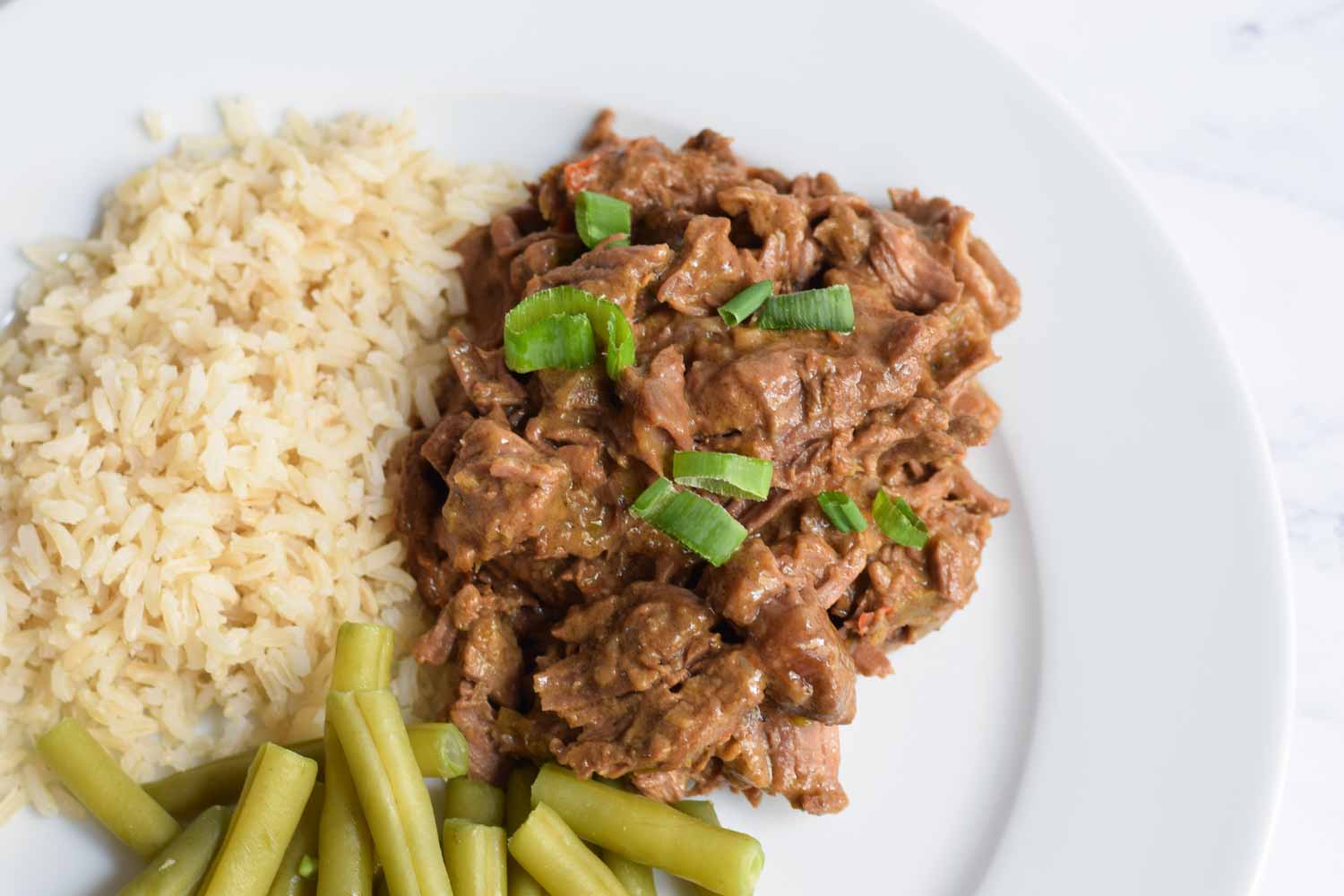 Low FODMAp rendang on a plate with rice and green beans