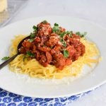 Low FODMAP pasta al ragù on a plate with a spoon in it