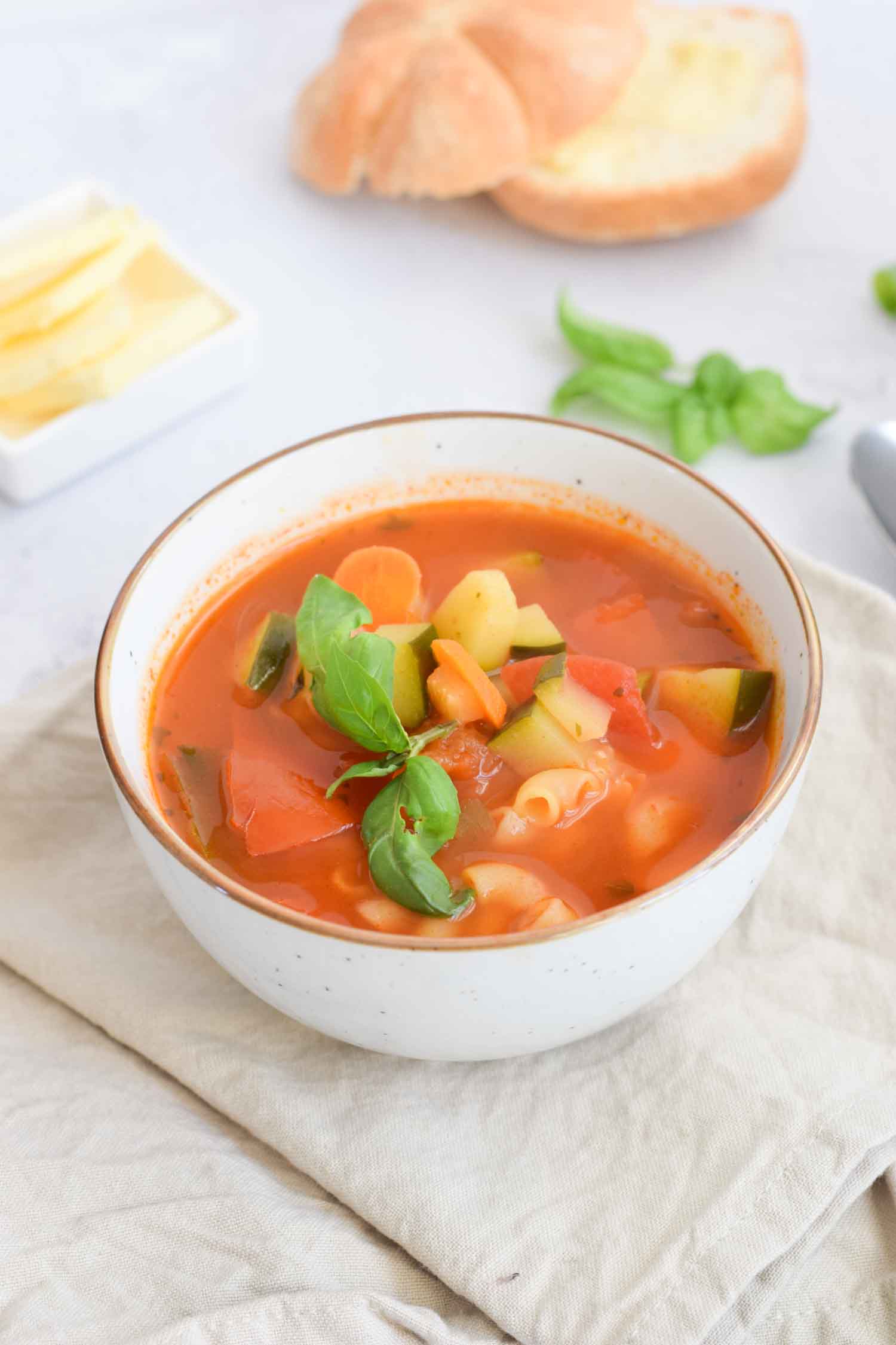 Low FODMAP minestrone soup in a bowl on a napkin