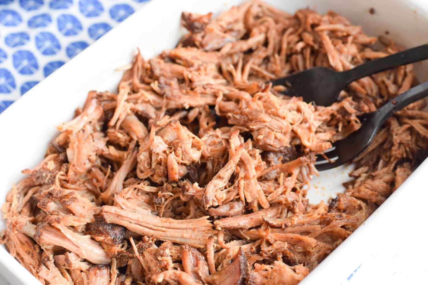 A bowl of low FODMAP pulled pork with two forks in it