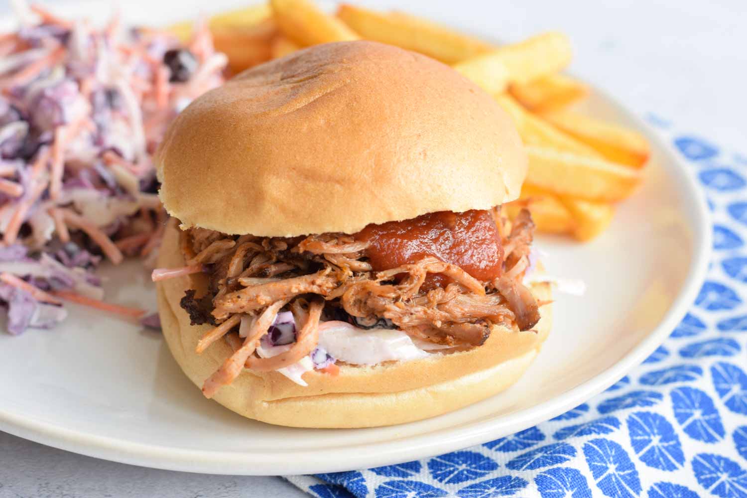 Low FODMAP pulled pork on a bun with coleslaw and fries