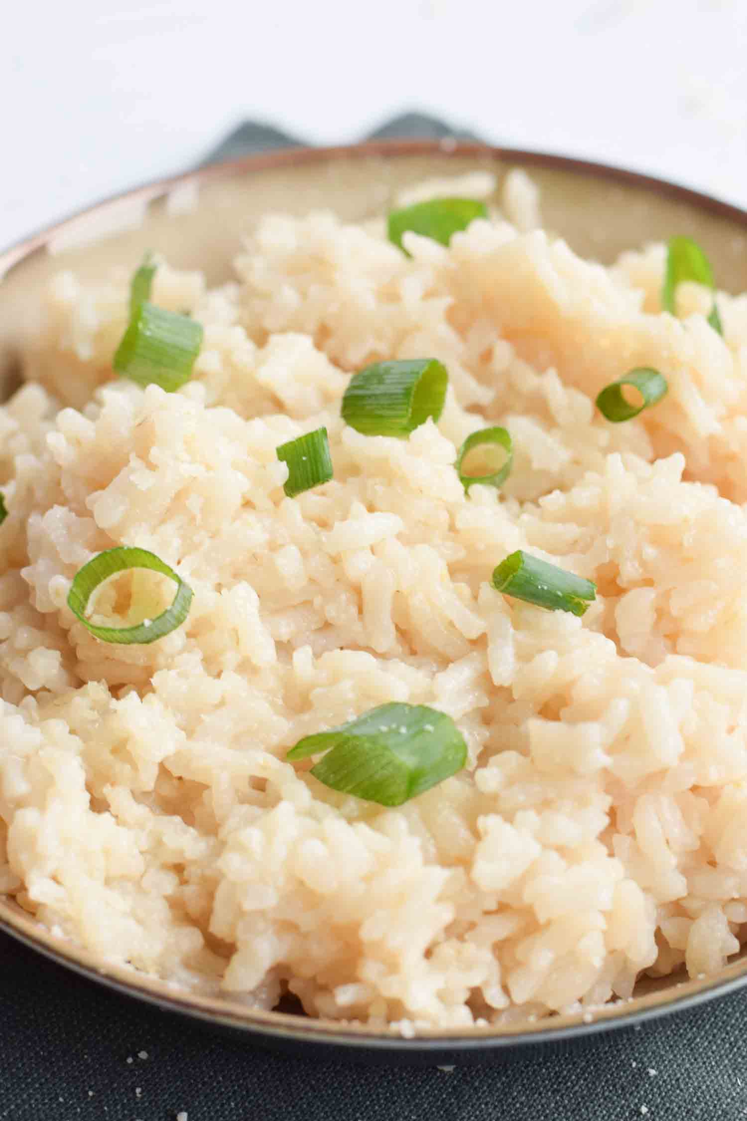 A bowl of risotto zoomed in with spring onion on top