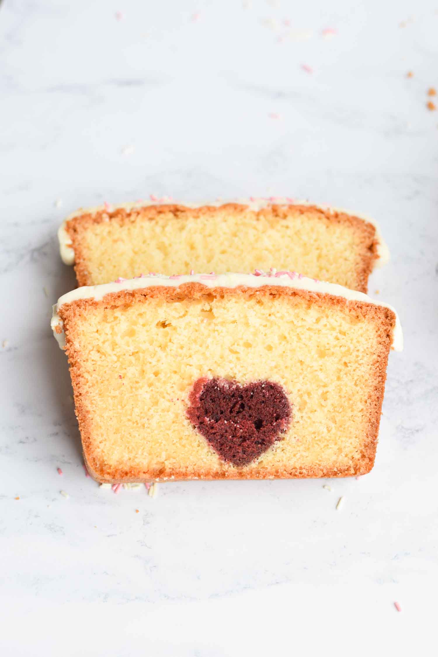 Two slices of vanilla cake with a heart inside
