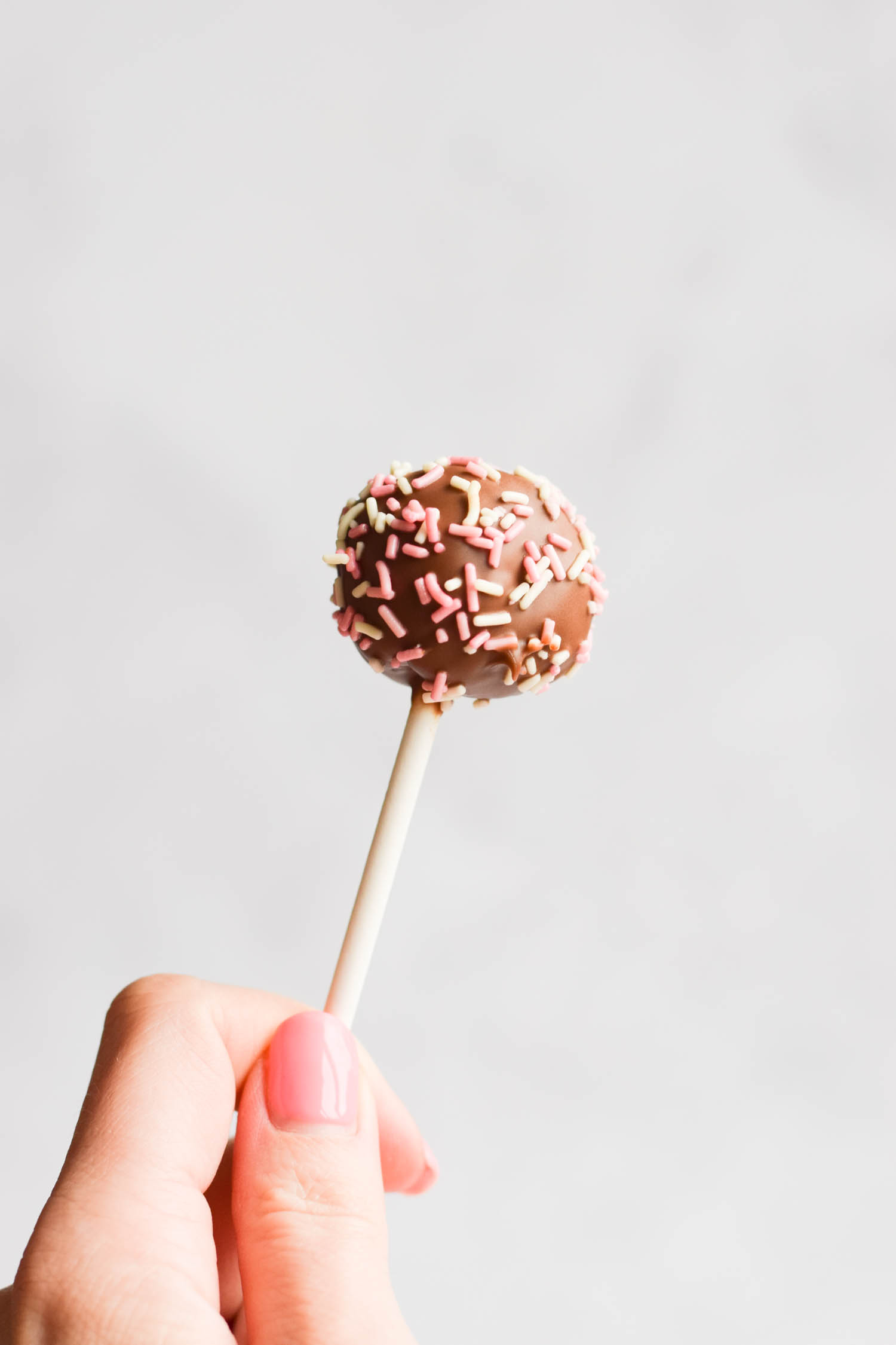 A gluten-free cake pop with chocolate and sprinkles