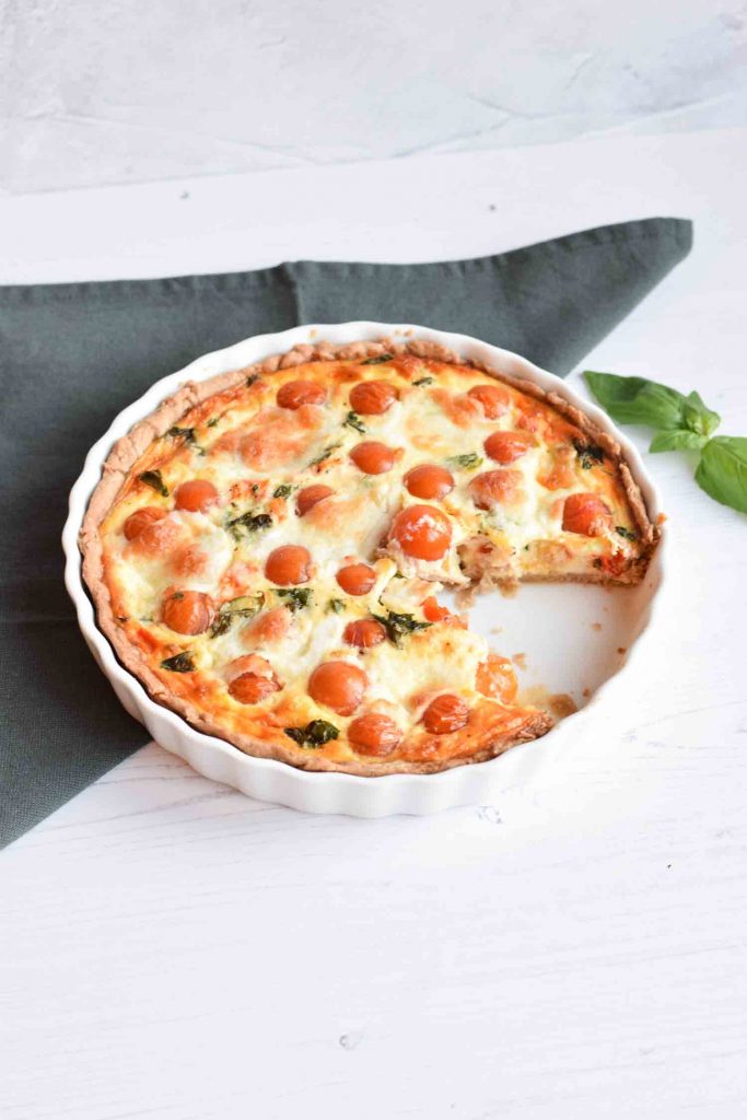 Gluten-free quiche caprese with one piece out of it