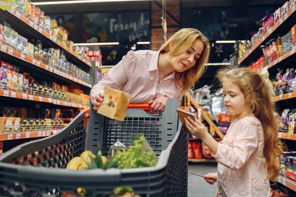 A mother grocery shopping with a kid