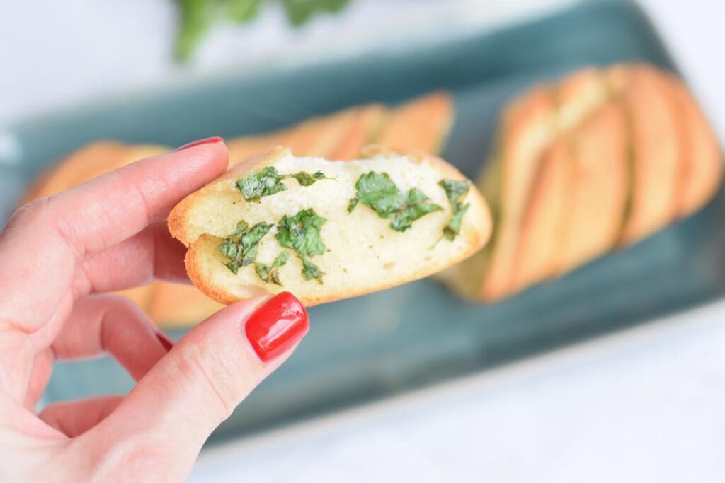 A piece of gluten-free herb butter bread in a hand
