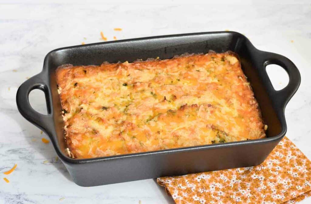 Een ovenschotel met broccoli, rijst, geraspte kaas en bechamelsaus