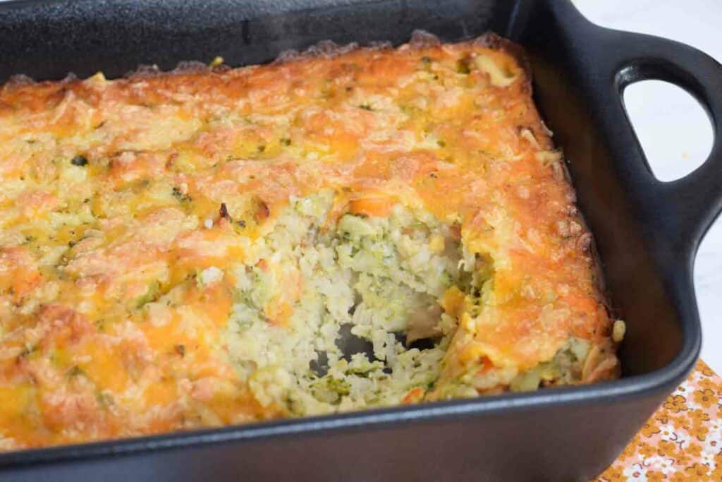Een ovenschotel met broccoli en rijst met een hapje eruit