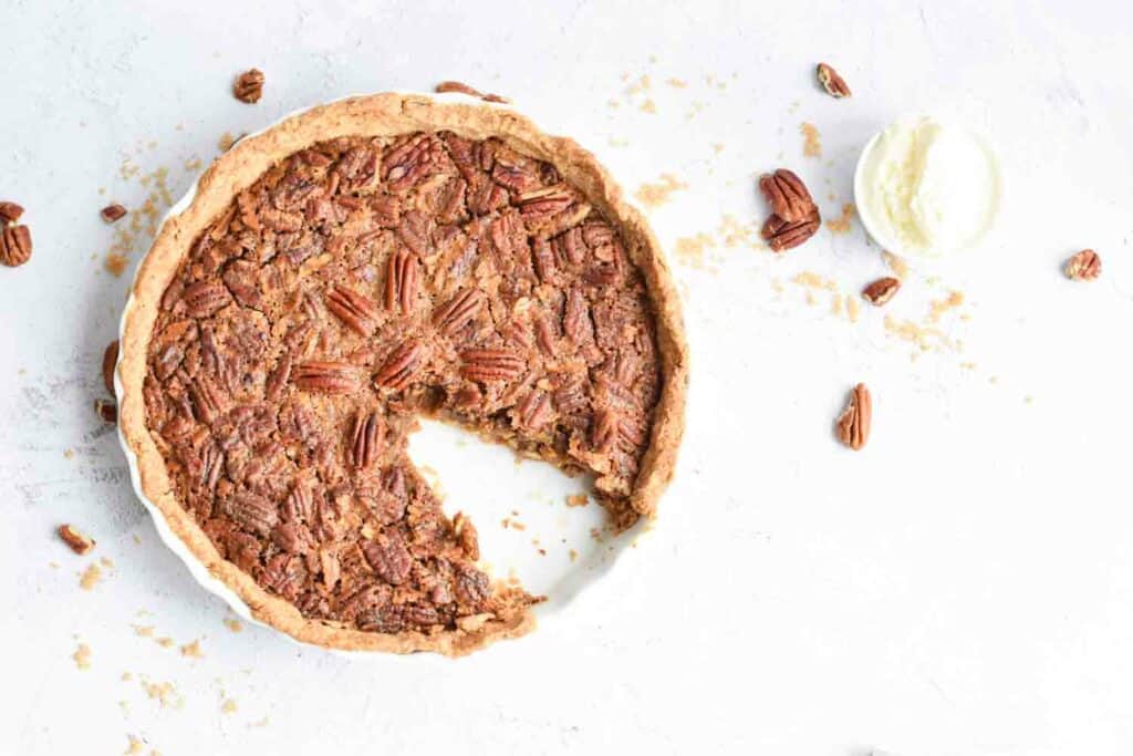A low FODMAP pecan pie photographed from above with a piece out of it