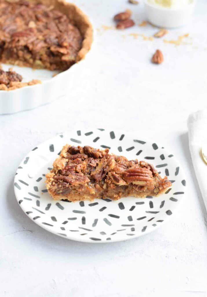A piece of low FODMAP pecan pie on a white and black plate