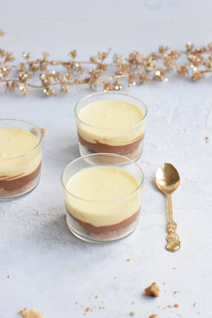 Three glasses of low FODMAP chocolate mousse with a golden spoon next to it