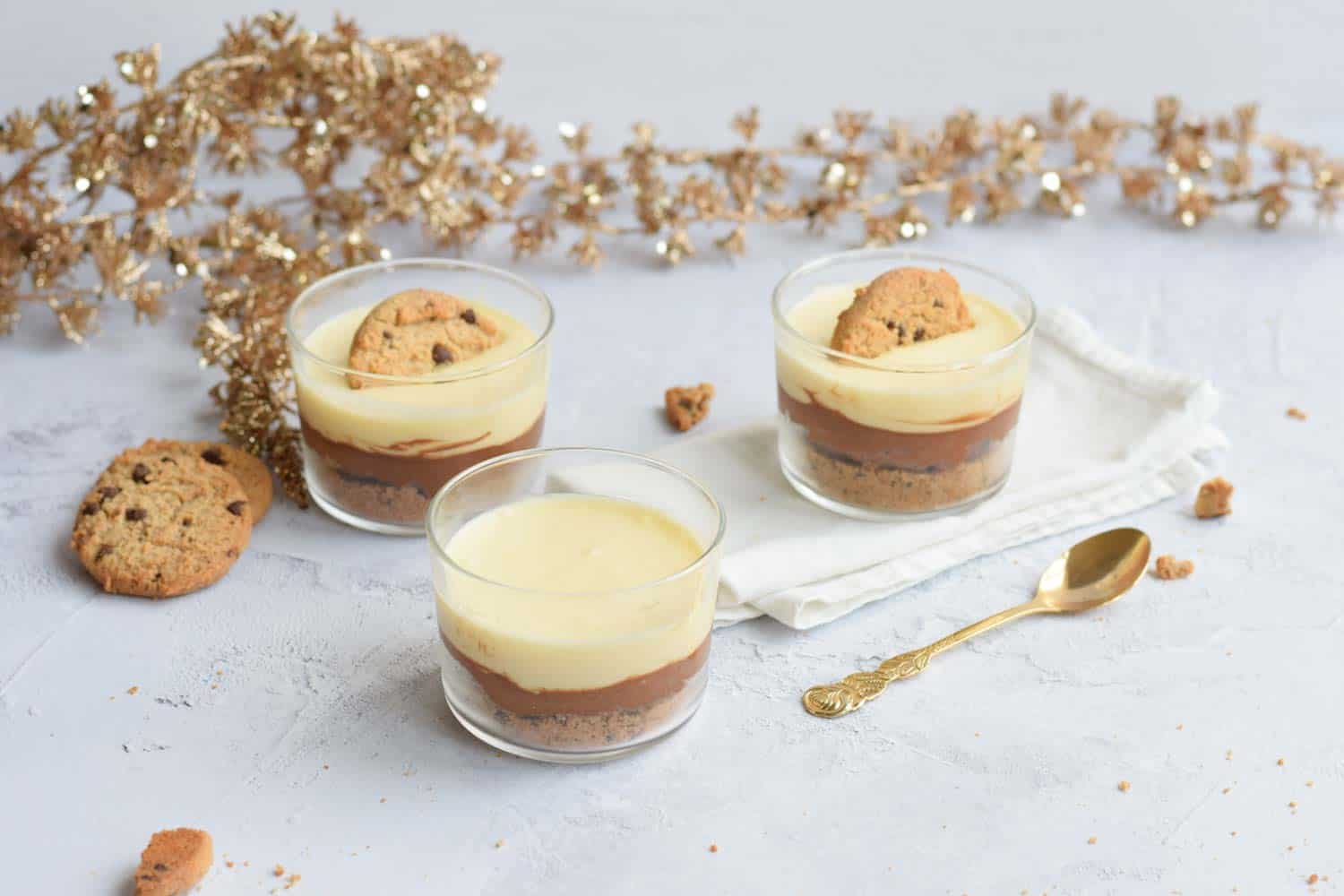 Three glasses of chocolate mousse and two have half a cookie on top