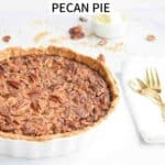 A low FODMAP pecan pie in a pie tin with a white napkin with golden cutlery next to it
