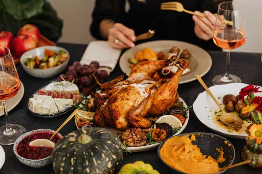 A dinner on the table with a turkey in the middle