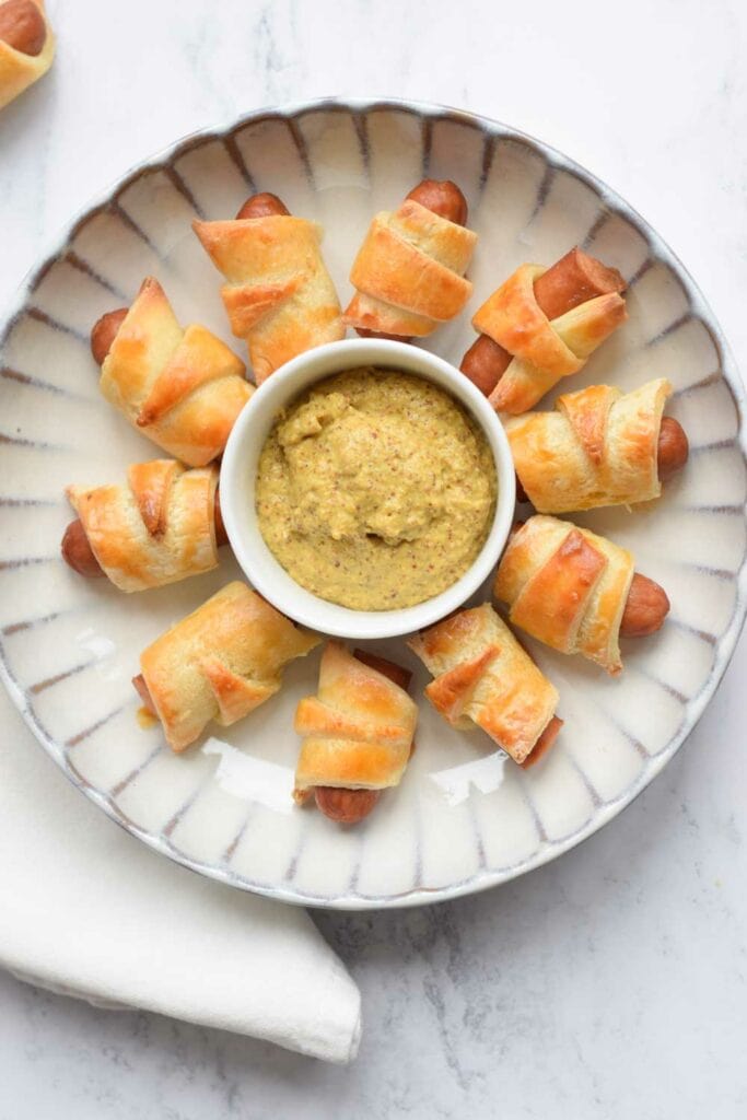 A plate of low FODMAP pigs in a blanket photographed from above