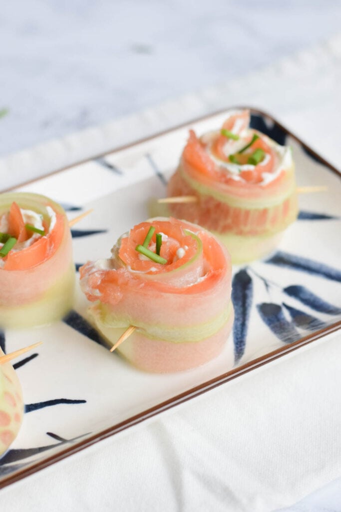 Low FODMAP salmon cucumber rolls with cream cheese on a plate
