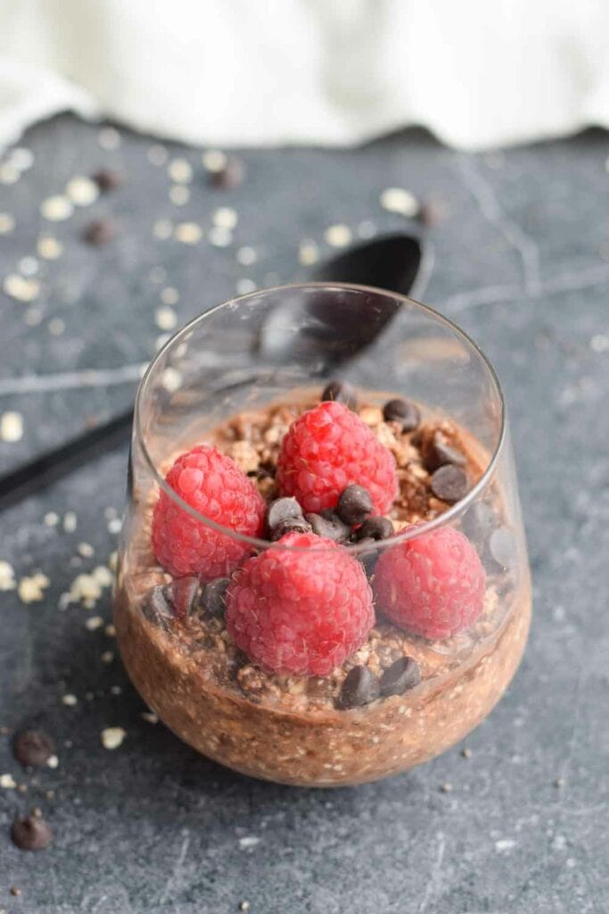Overnight oats in a glass with raspberries and chocolate chips
