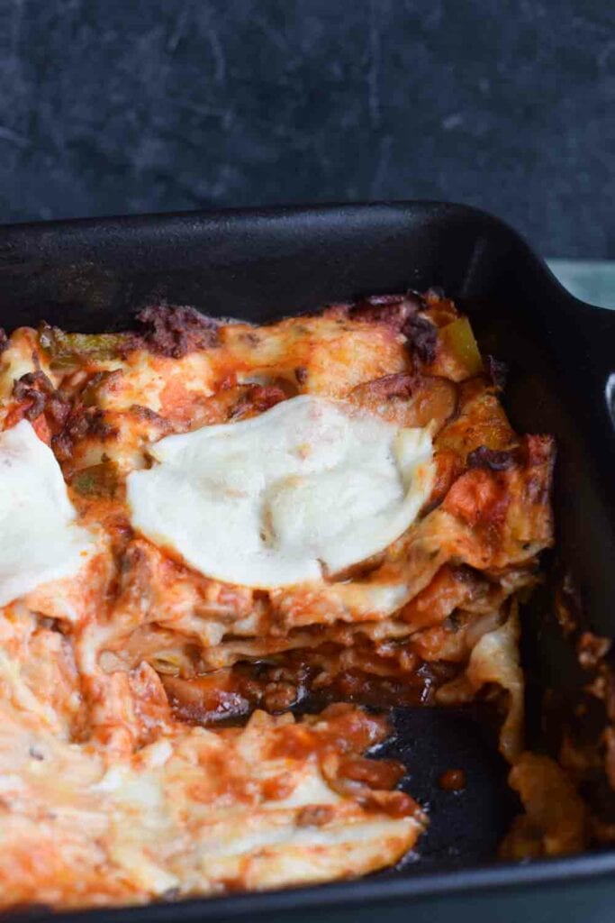 A dish of low FODMAP lasagna bolognese with a piece out of it