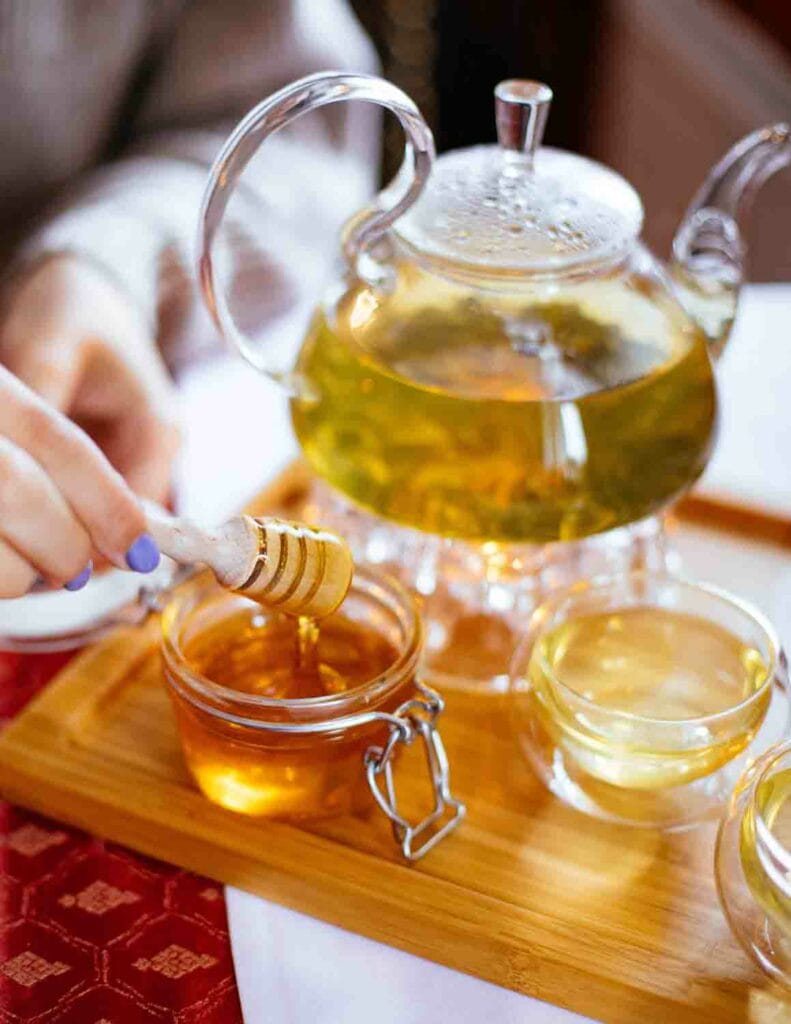 Een kommetje met honing met een dienblad met thee