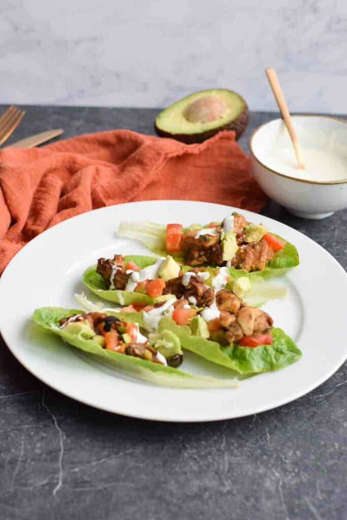 A plate with low carb chicken shawarma in lettuce wraps