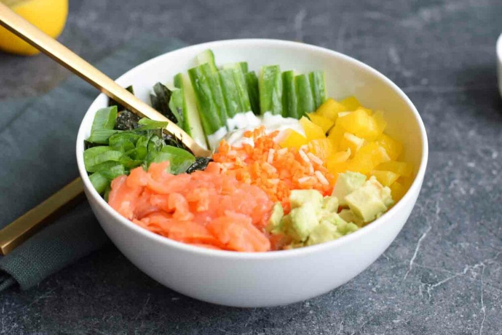 A low carb poké bowl with carrot rice, smoked salmon and veggies