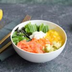 Een kleurrijke koolhydraatarme poké bowl met gerookte zalm, groenten en wortelrijst