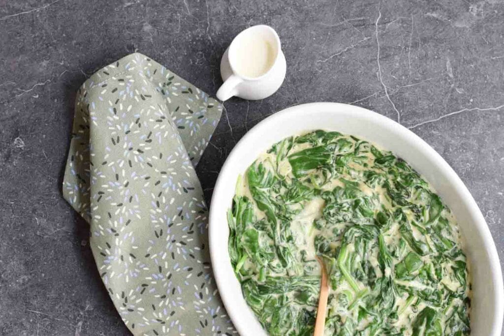 Low FODMAP creamed spinach with cream next to it