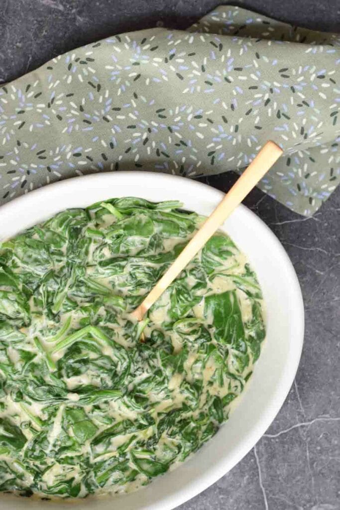 Low FODMAP creamed spinach in a dish with a napkin next to it