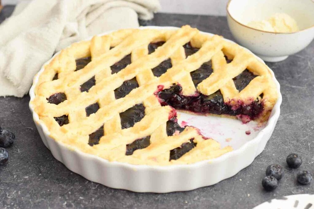 A low FODMAP blueberry pie with a piece out of it