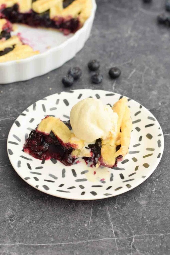A piece of low FODMAP blueberry pie with ice cream on top