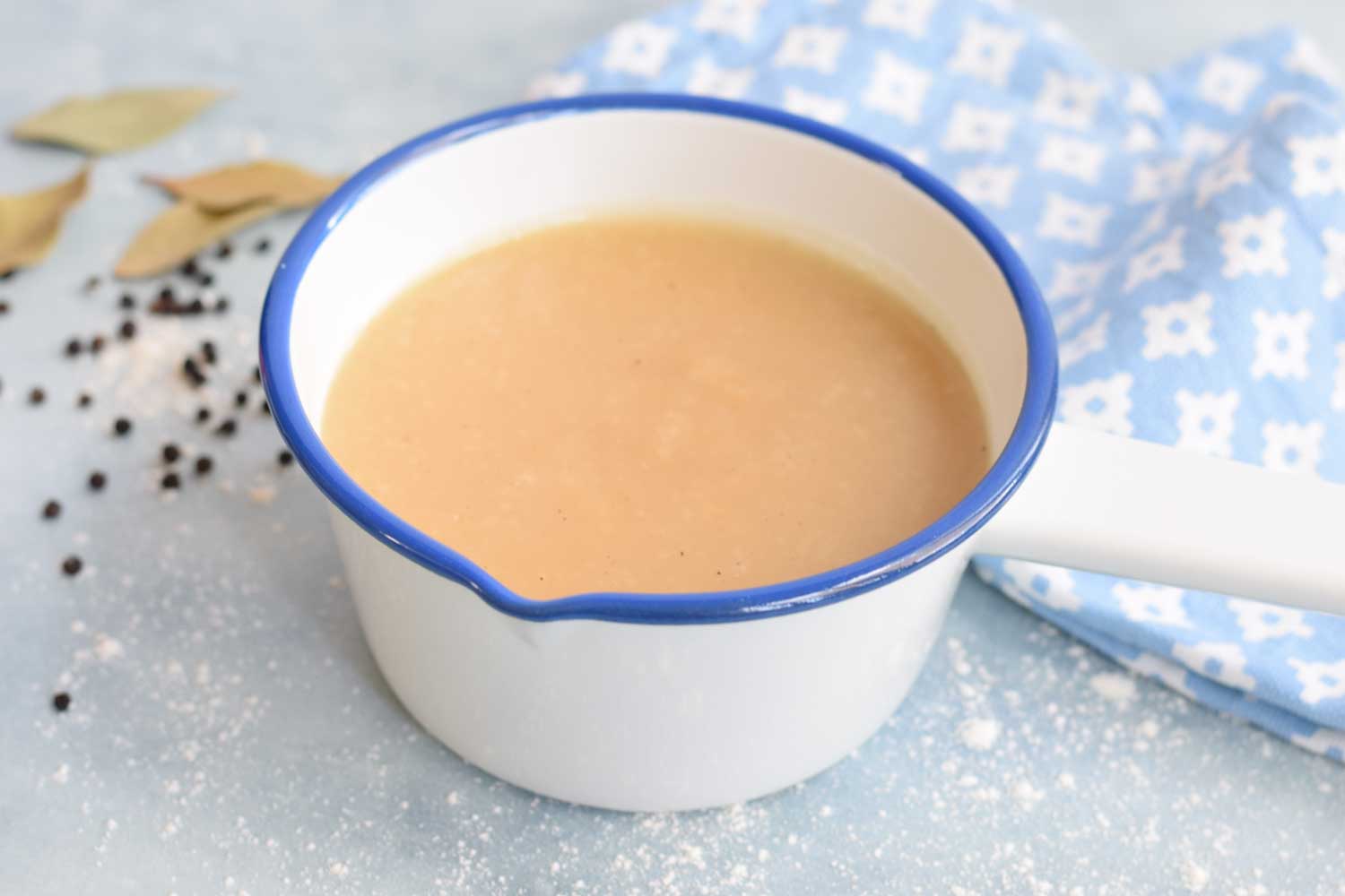 A white with blue pan with gravy in it