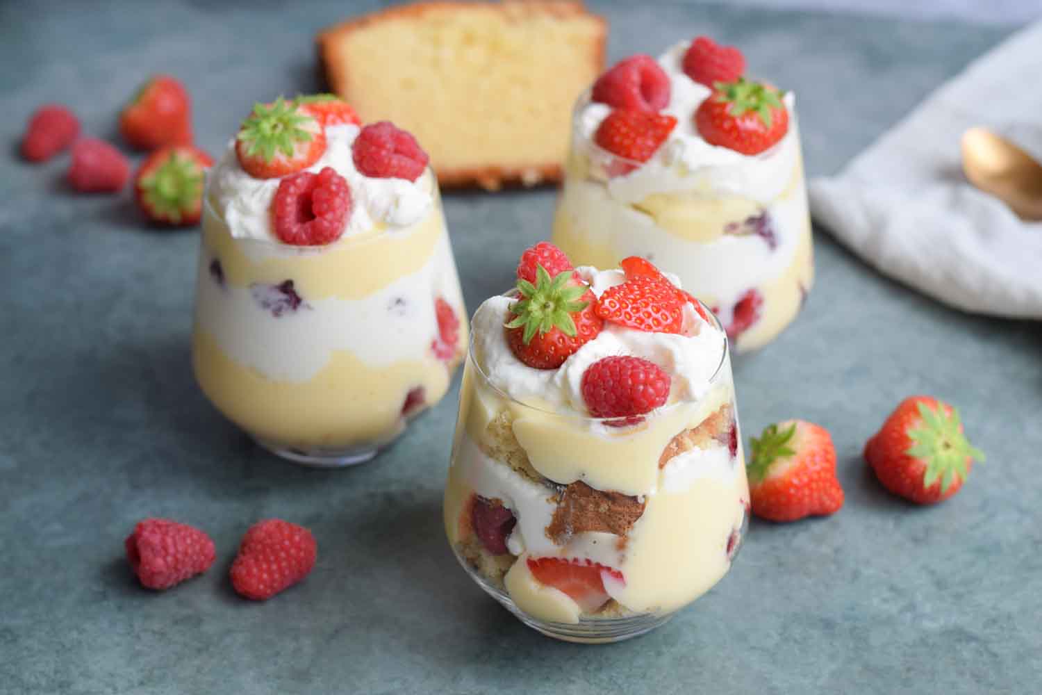 Low FODMAP mini trifles in a glass with strawberries next to it