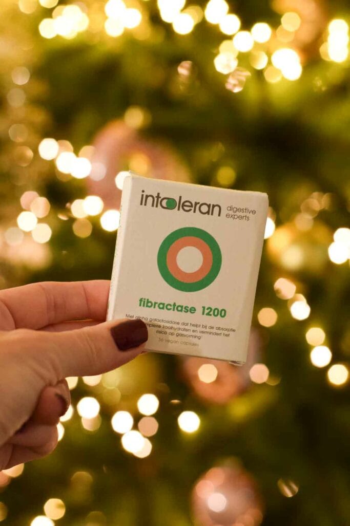 Somebody holding a box of Fibractase in front of a Christmas tree