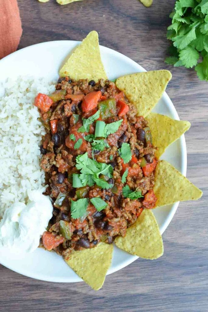 A plate of low FODMAP chili con carne with rice and sour cream